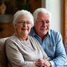 Smiling retired couple comfortably in their refurbished living room