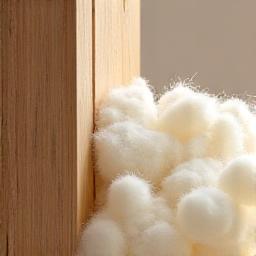 Natural fiber insulation being installed in a wall cavity, showcasing a healthy building material.